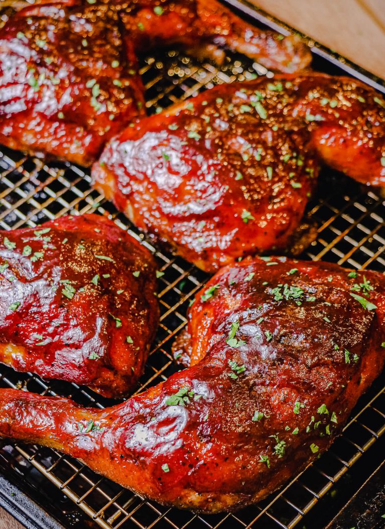 grilled chicken quarters on a cooling rack garnished with parsley