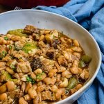 bowl of pinto beans with peppers and a blue napkin