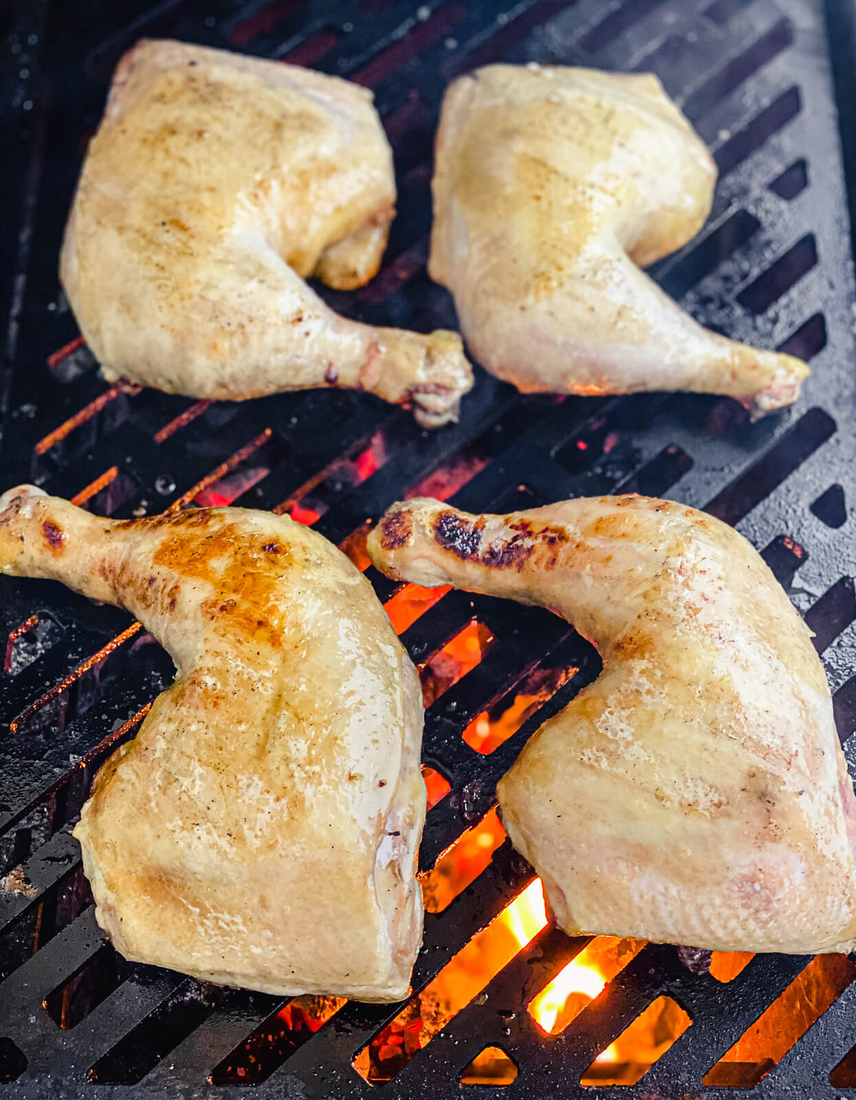 grilled chicken quarters on the grill skin side up
