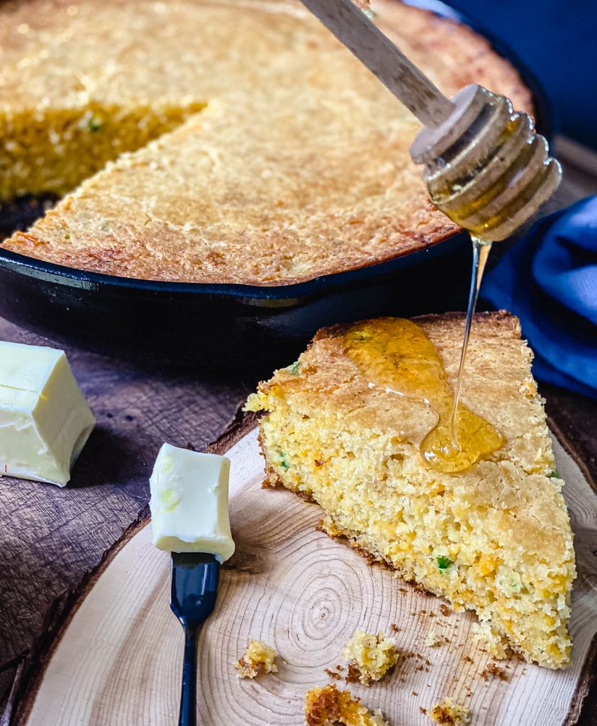 jalapeno cheddar corn bread being topped with honey