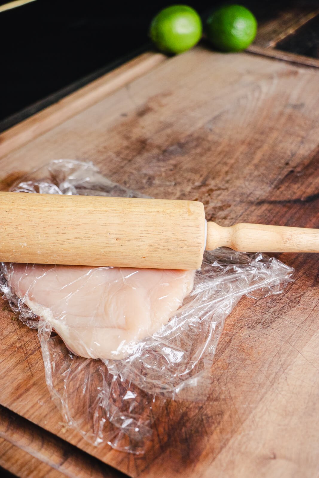 raw chicken breast flattened by rolling pin