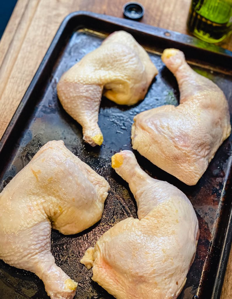 raw chicken quarters rubbed with avocado oil