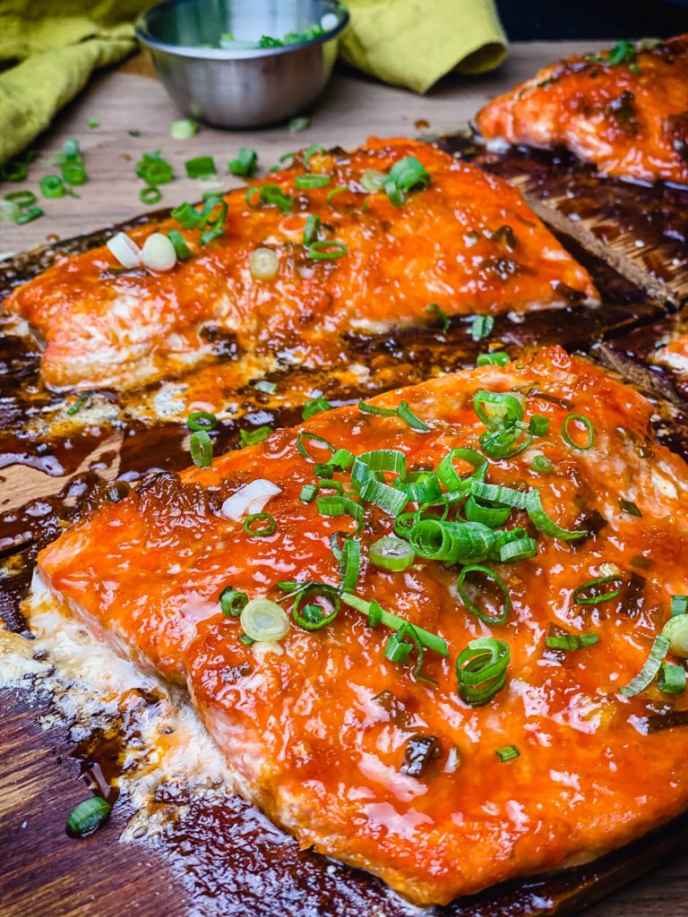 green onions on top of honey sriracha plank salmon