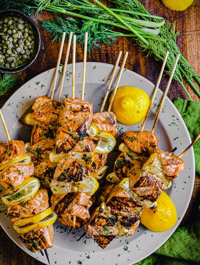 plate of salmon kabobs with lemon and dill