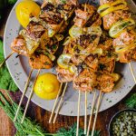 plate of salmon kabobs with lemon and dill