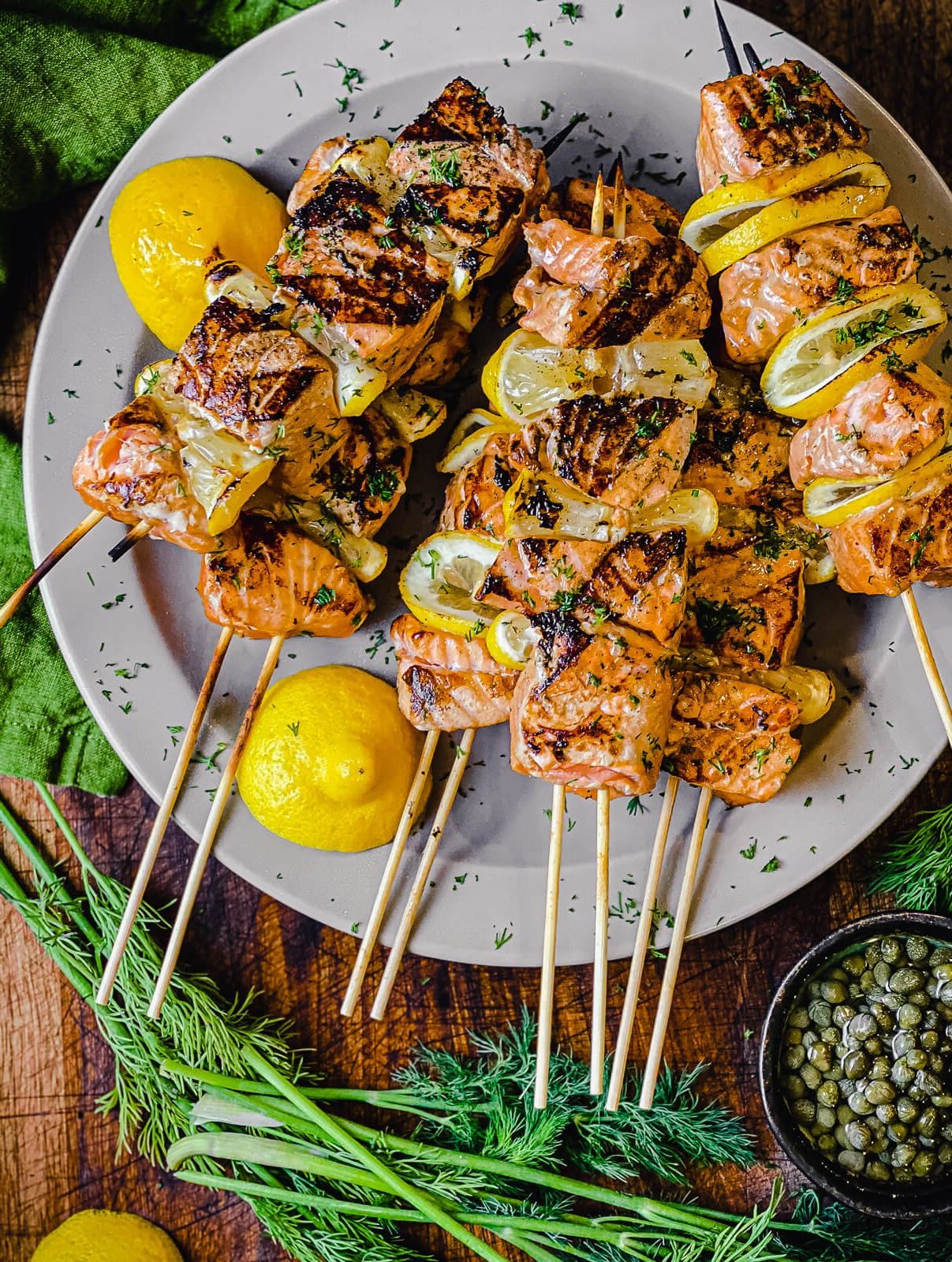 plate of salmon kabobs with lemon and dill