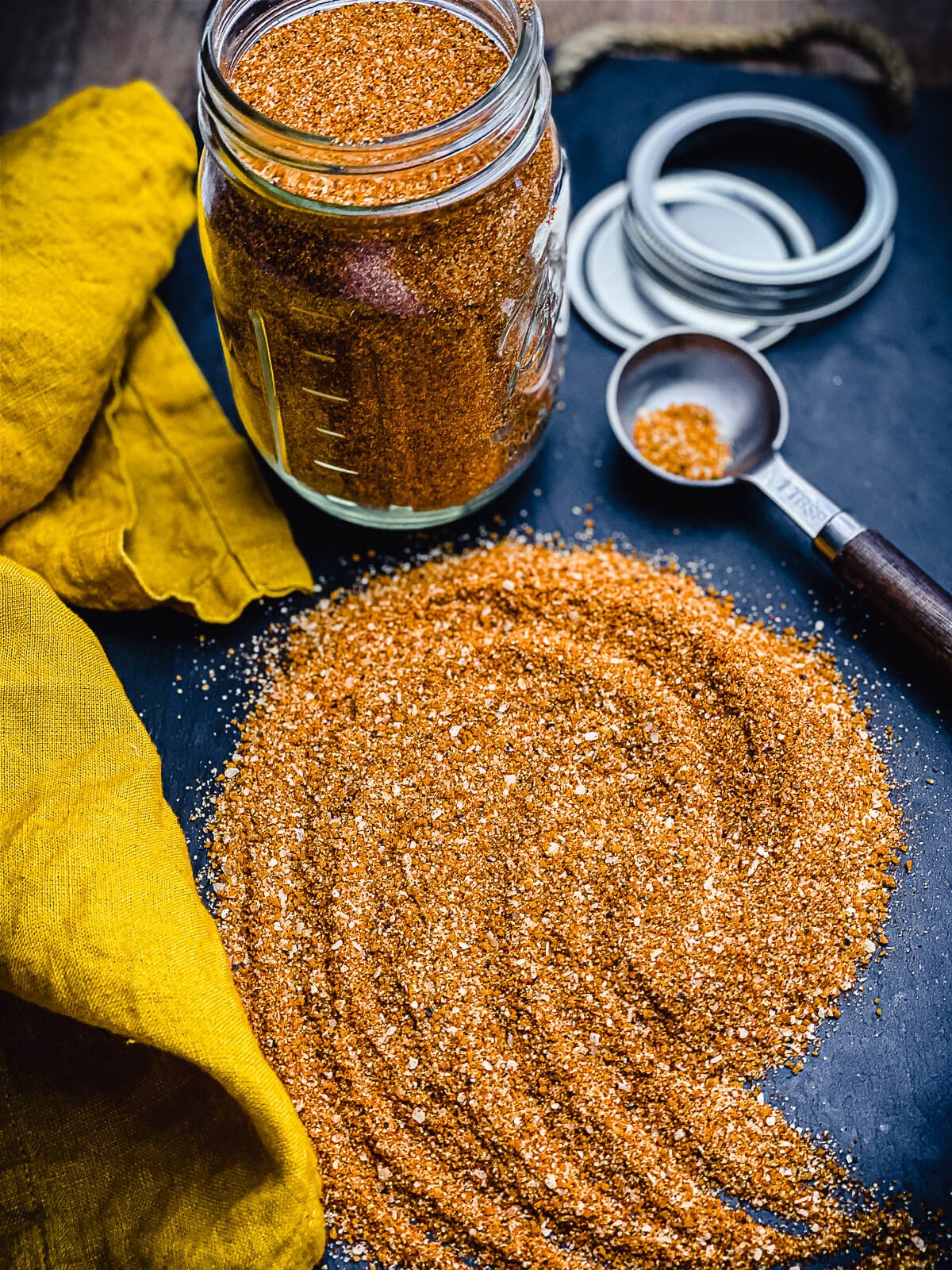 homemade bbq rub in a glass jar on a slate board