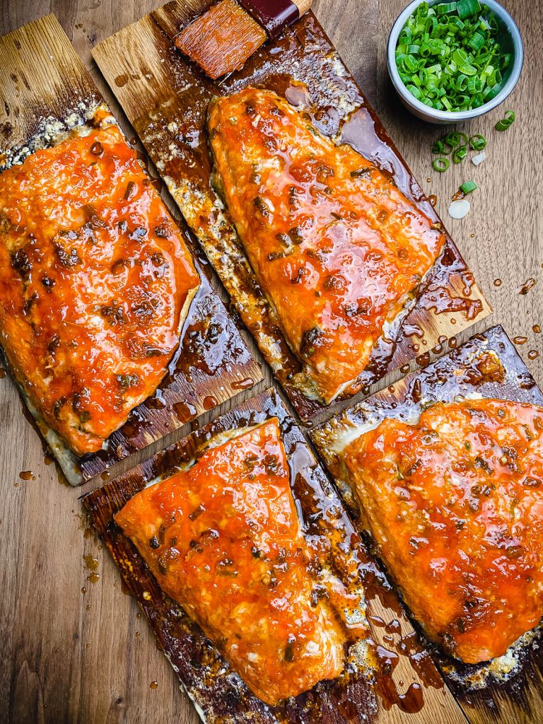 Cedar plank salmon on cutting board after coming off the grill