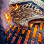 ribeye steak on the grill over fire