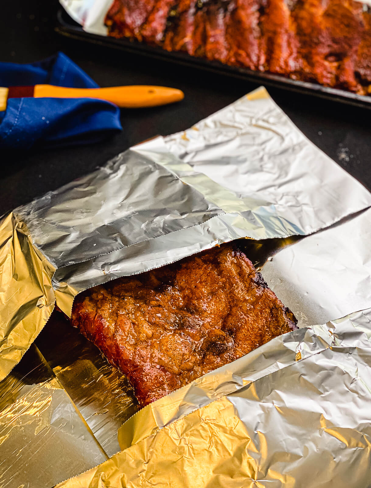 pork ribs being wrapped in tin foil