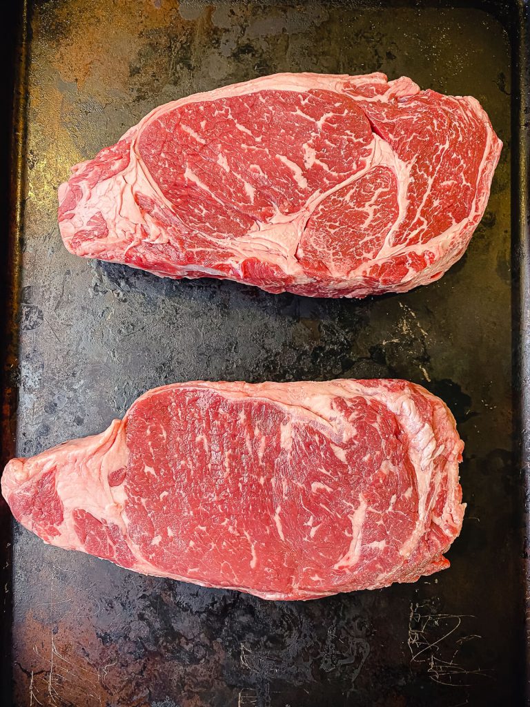 two ribeye steaks side by side