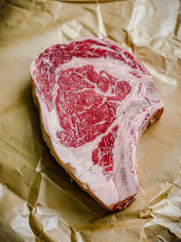 uncooked ribeye steak on butcher paper