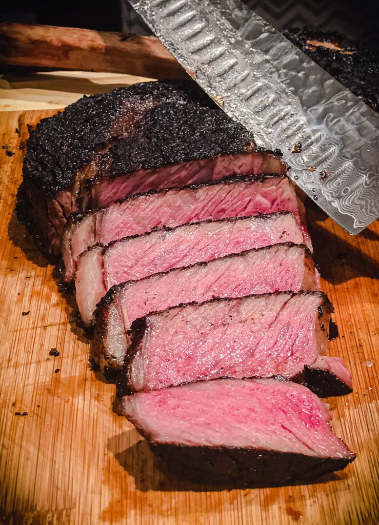 sliced ribeye steak on a cutting board