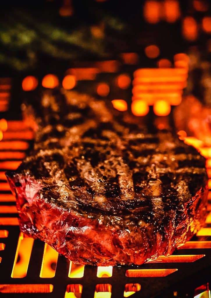 ribeye steak cooking on the kalamazoo gas grill head