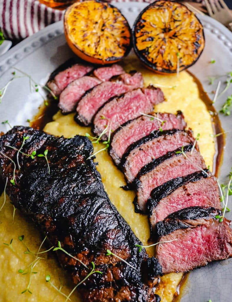 New York strip steak on a plate with palenta