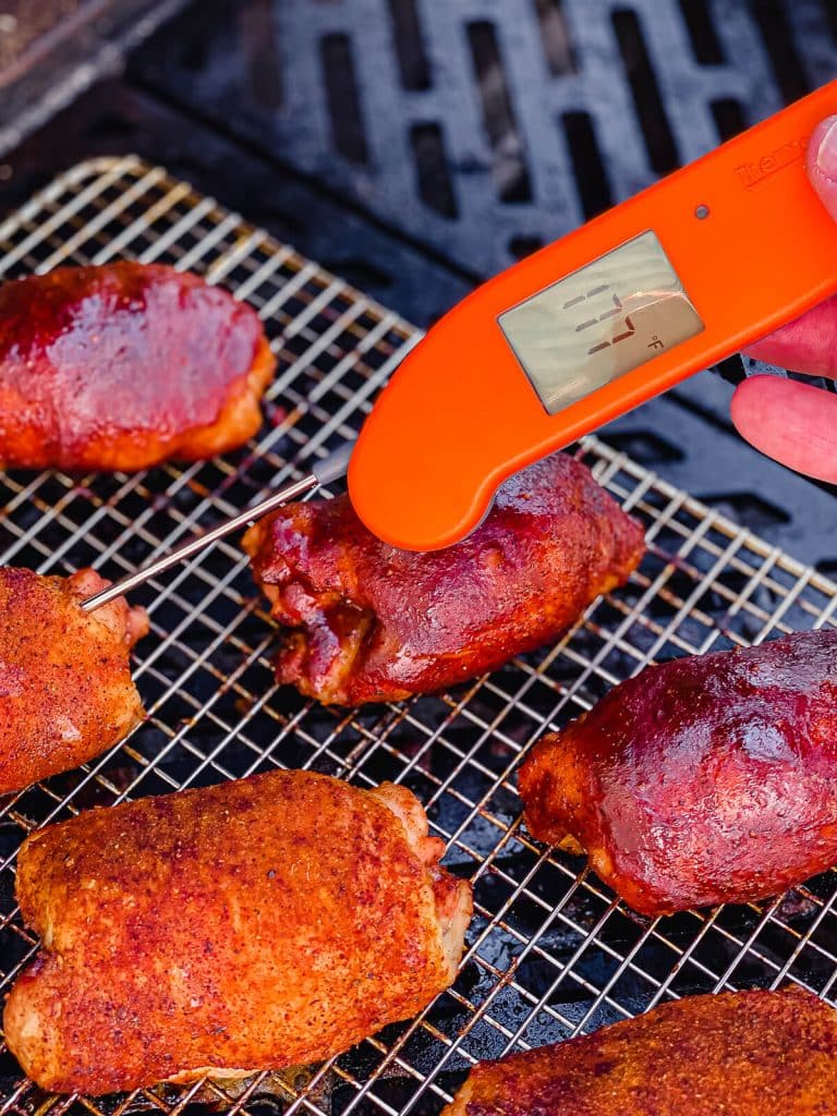 chicken thighs on the grill with a meat thermometer