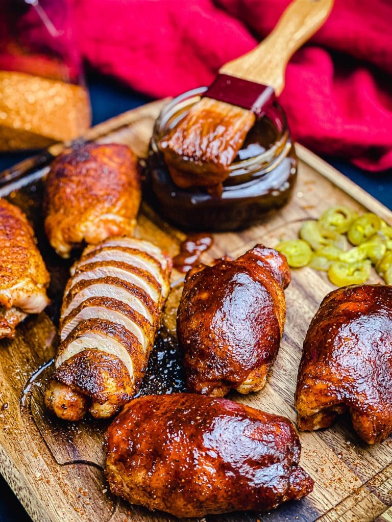 smoked chicken thighs on a wood platter with bbq sauce