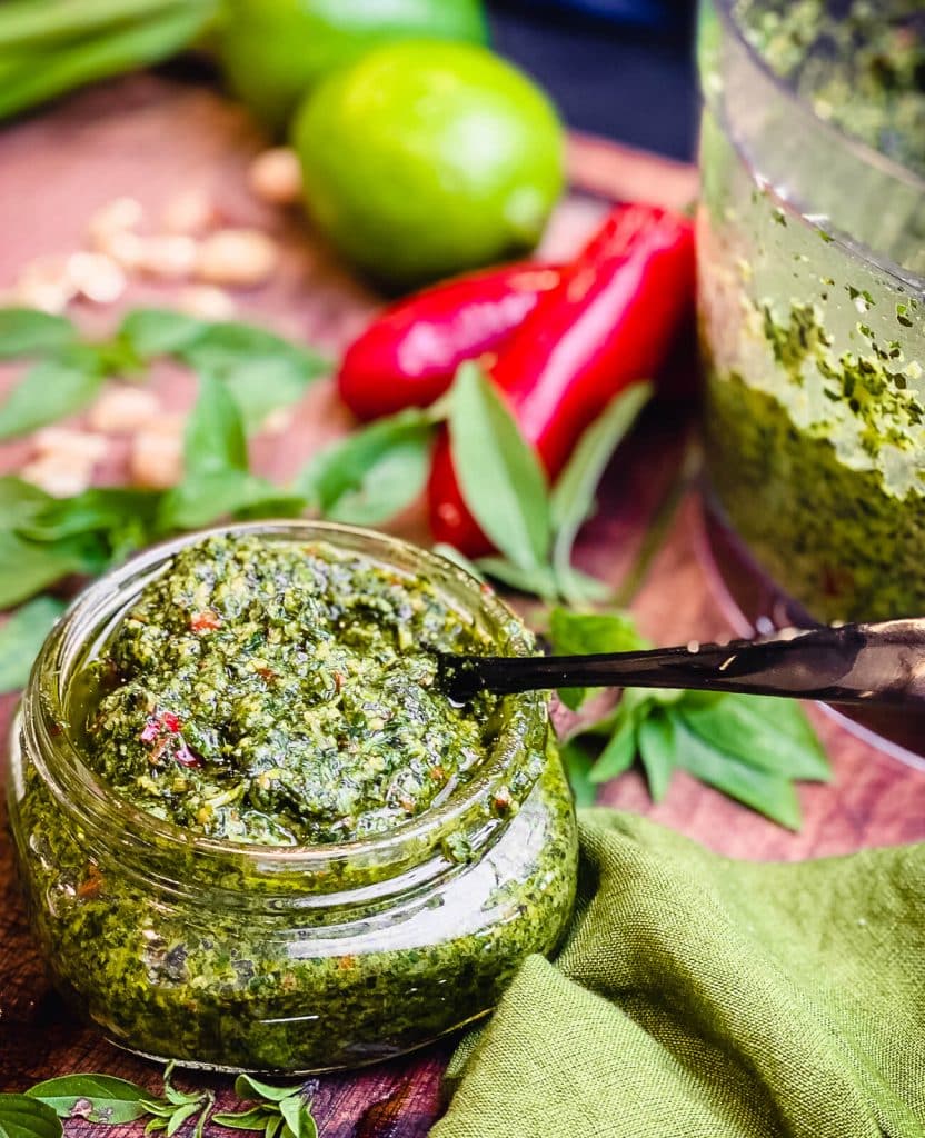 jar full of thai basil pesto with peppers in the background