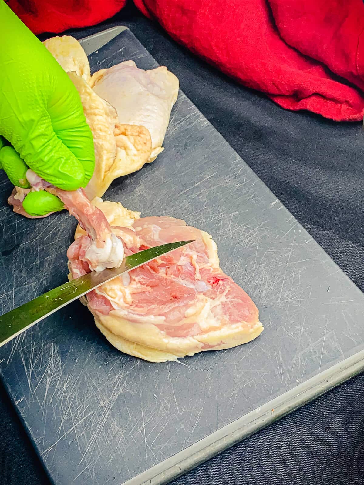 bone being cut from a chicken thigh