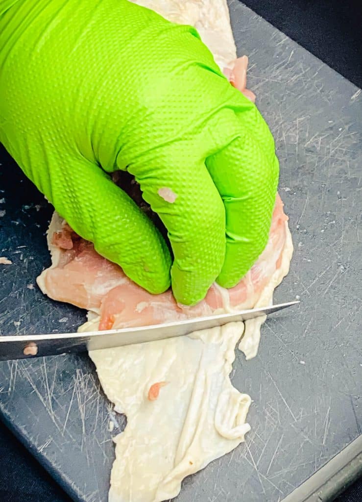 skin being removed from a chicken thigh