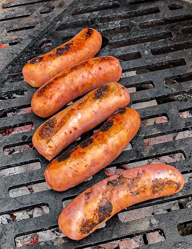 chorizo on a grill grate over hot coals