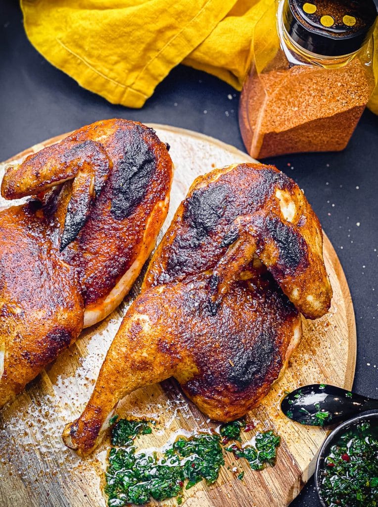 grilled chicken halves on a cutting board