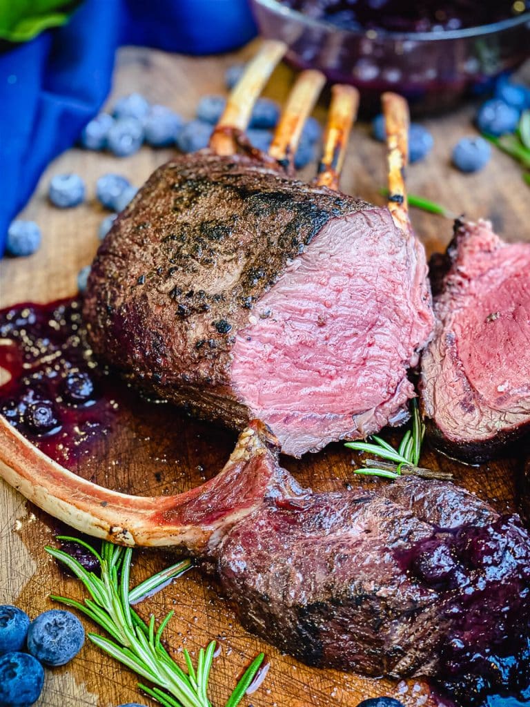 grilled rack of venison sliced on a cutting board