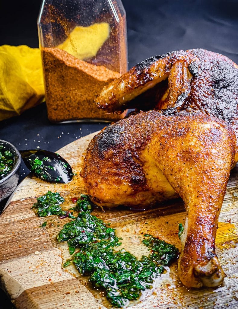 chicken drumstick on a cutting board with chimichurri