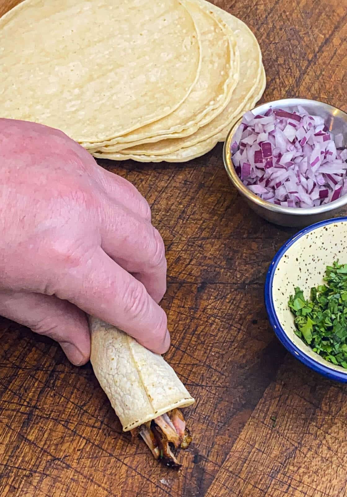 rolling taquitos on a cutting board