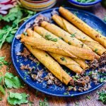 leftover carnitas taquitos on a blue plate