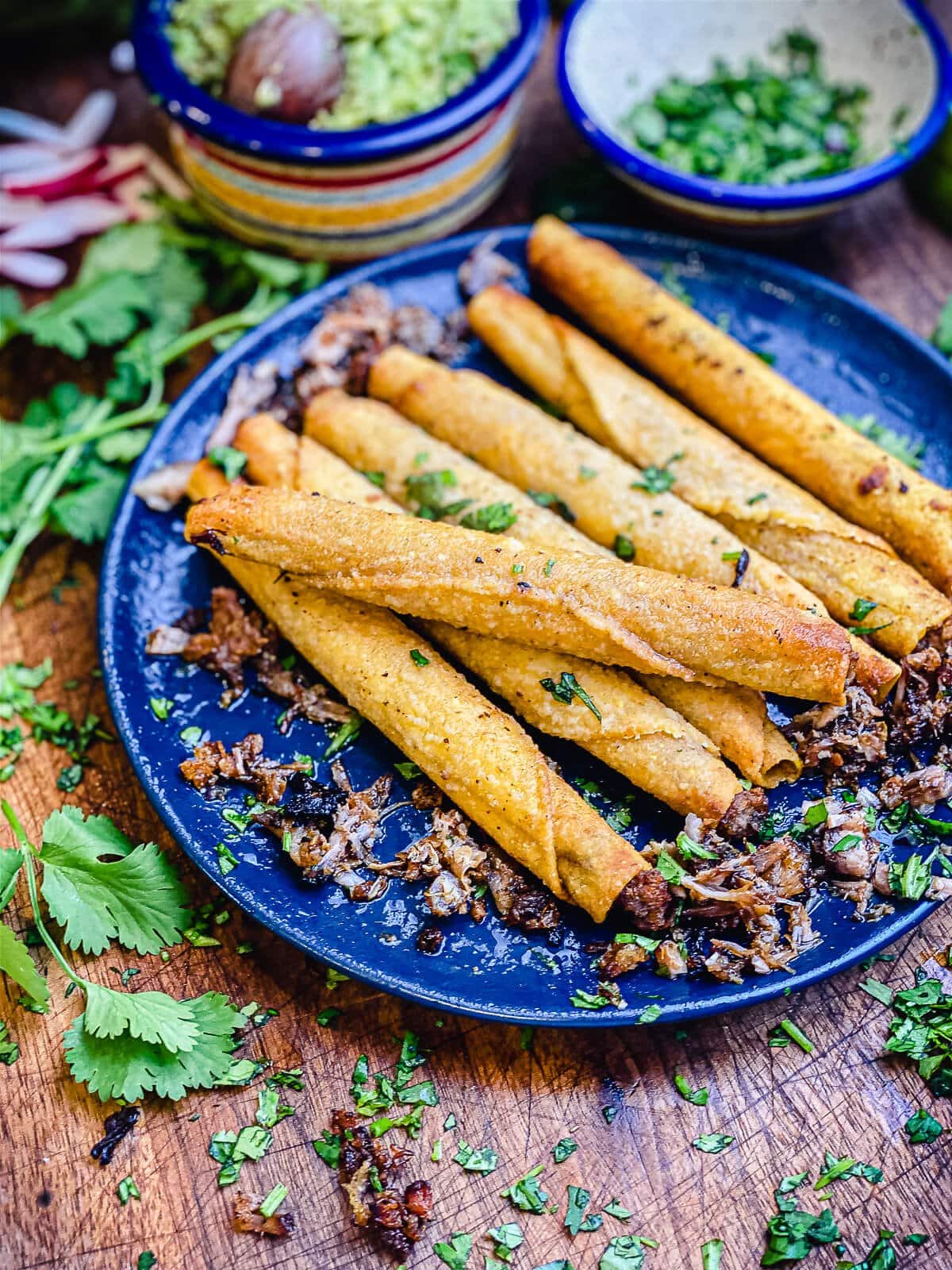 leftover carnitas taquitos on a blue plate