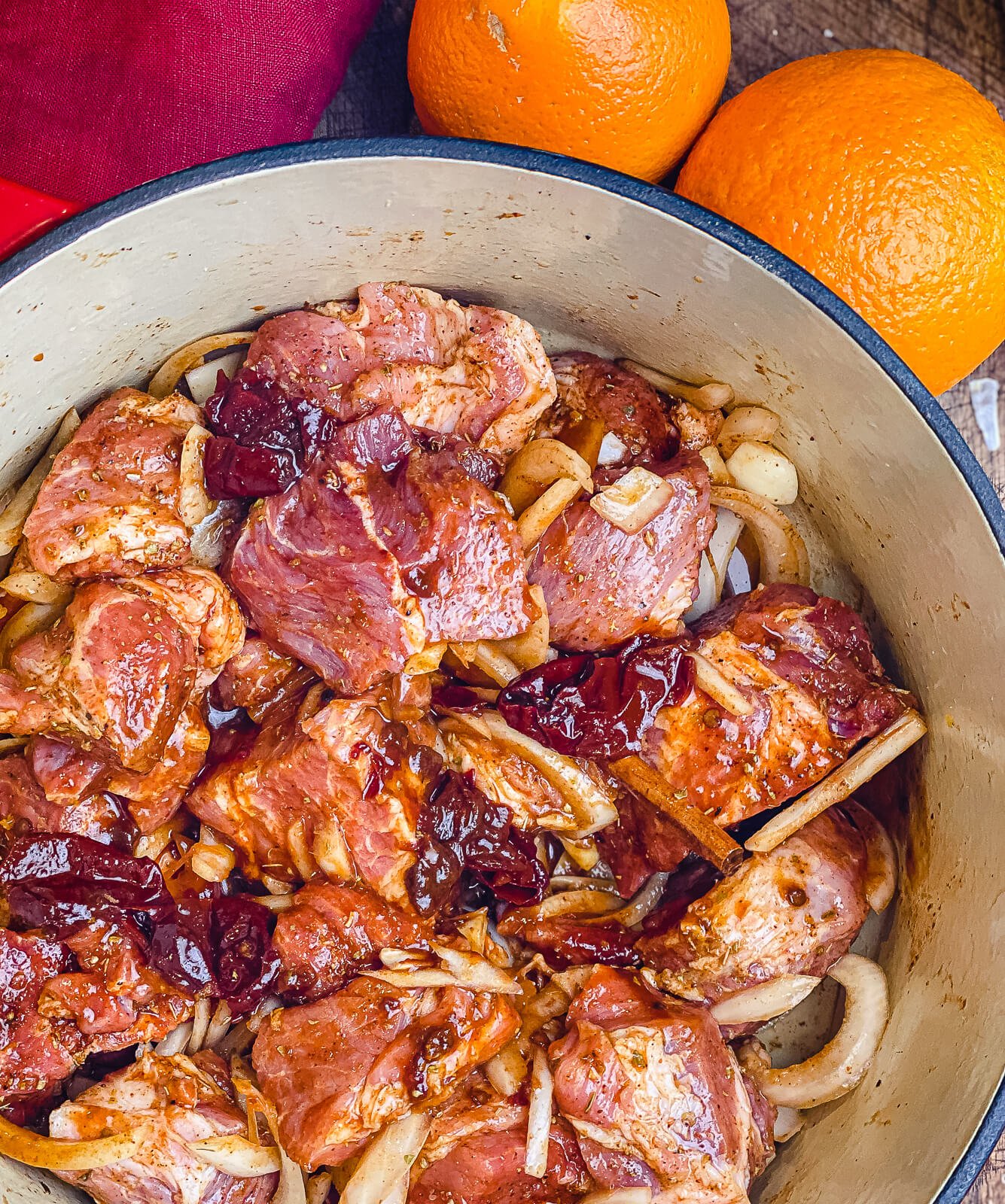 ingredients for pork carnitas mixed in a dutch oven