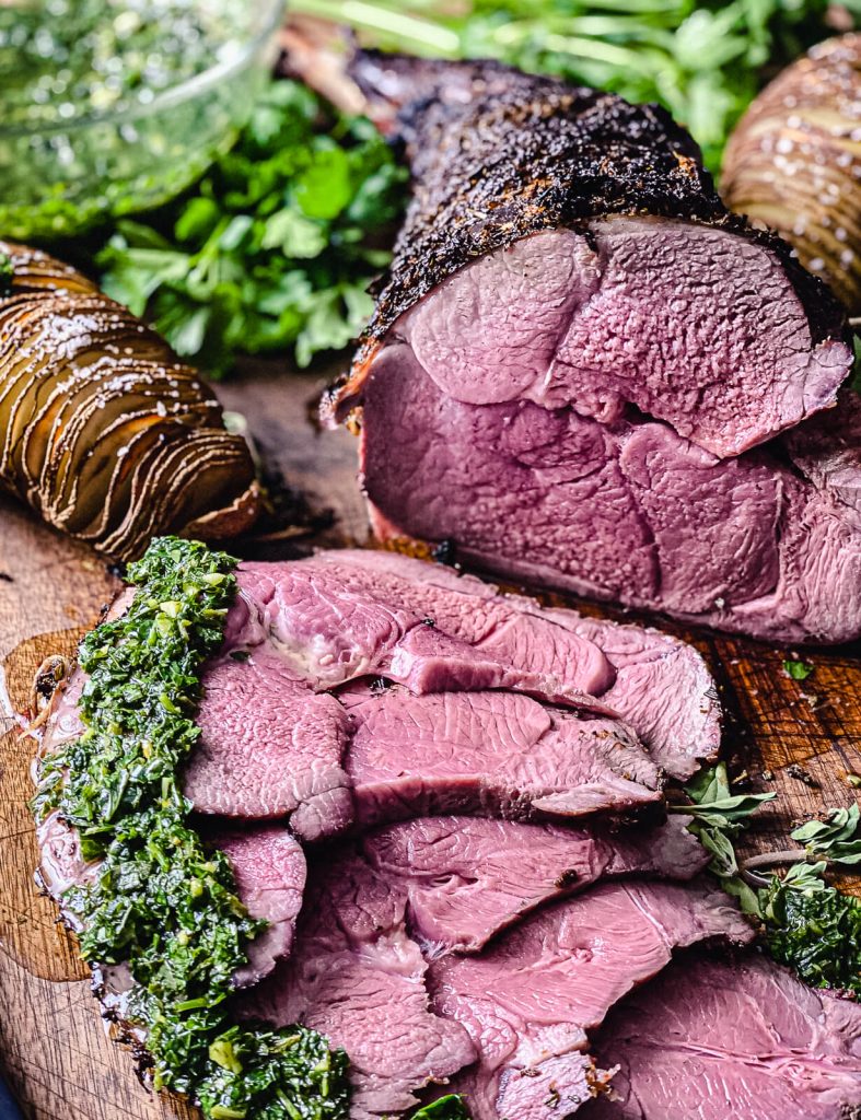 sliced smoked leg of lamb on a cutting board