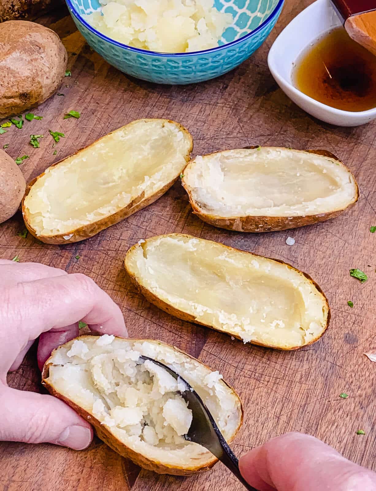 scooping out a baked potato with a spoon