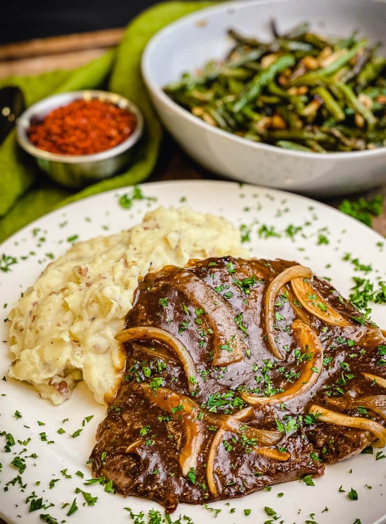 cube steak on a plate with potatoes and gravy