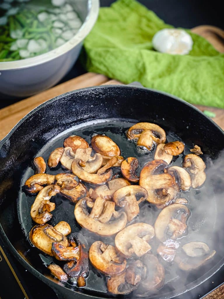 mushrooms browning in a cast iron pan