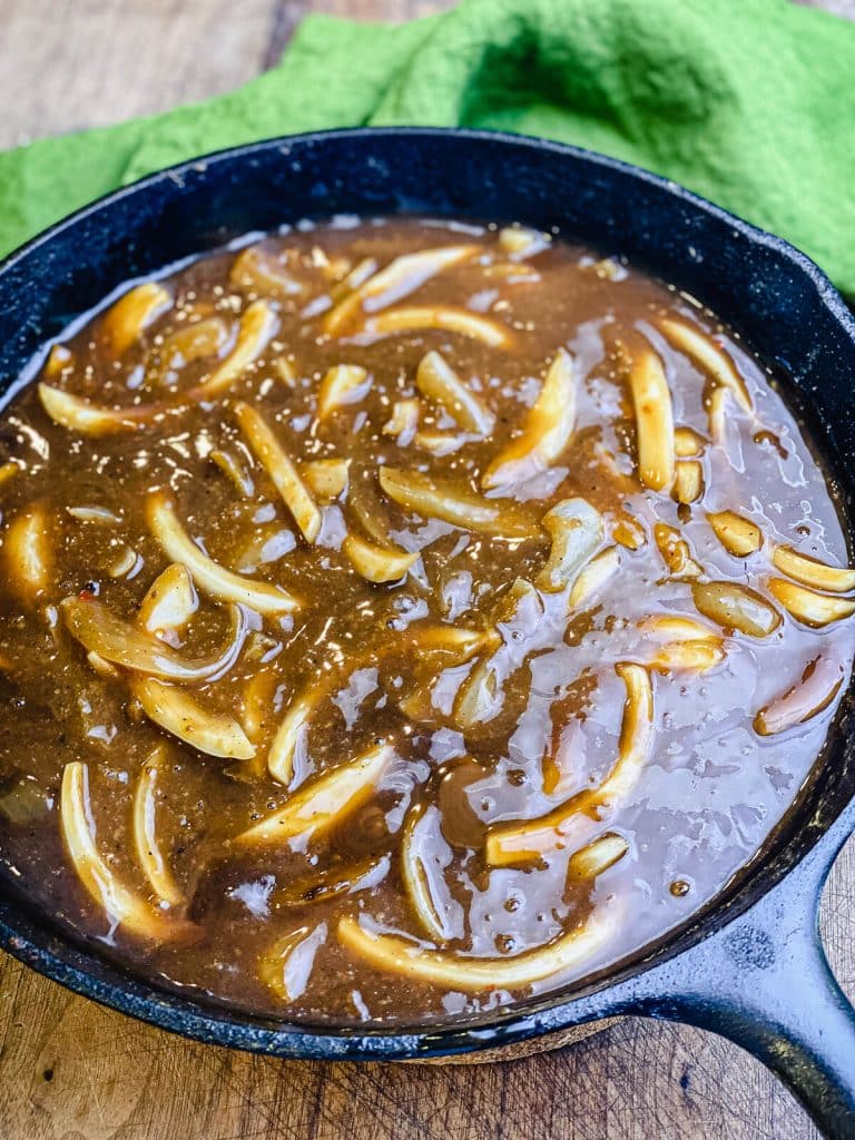 onion gravy cooking in a cast iron pan