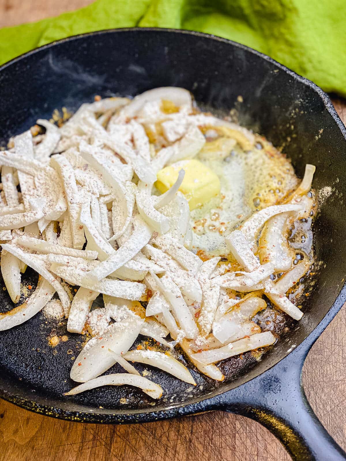 butter and onions cooking in cast iron pan