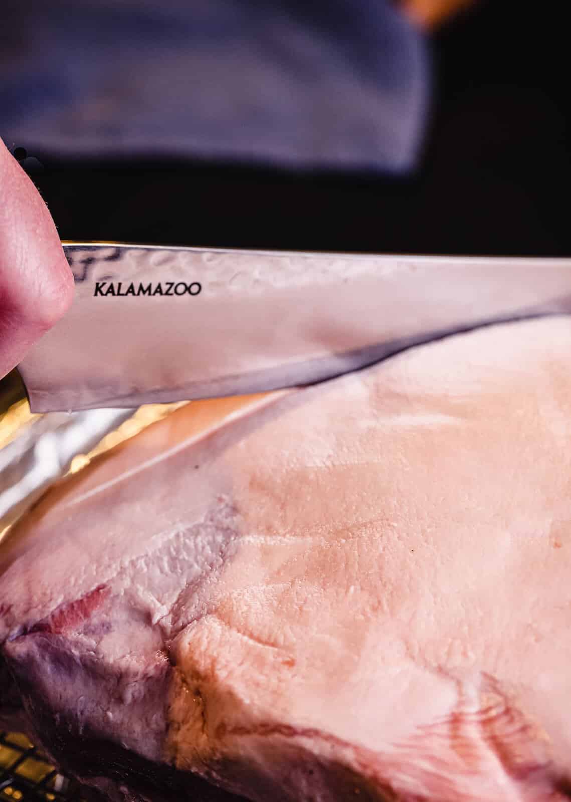 slicing hatch marks into a pork shoulder