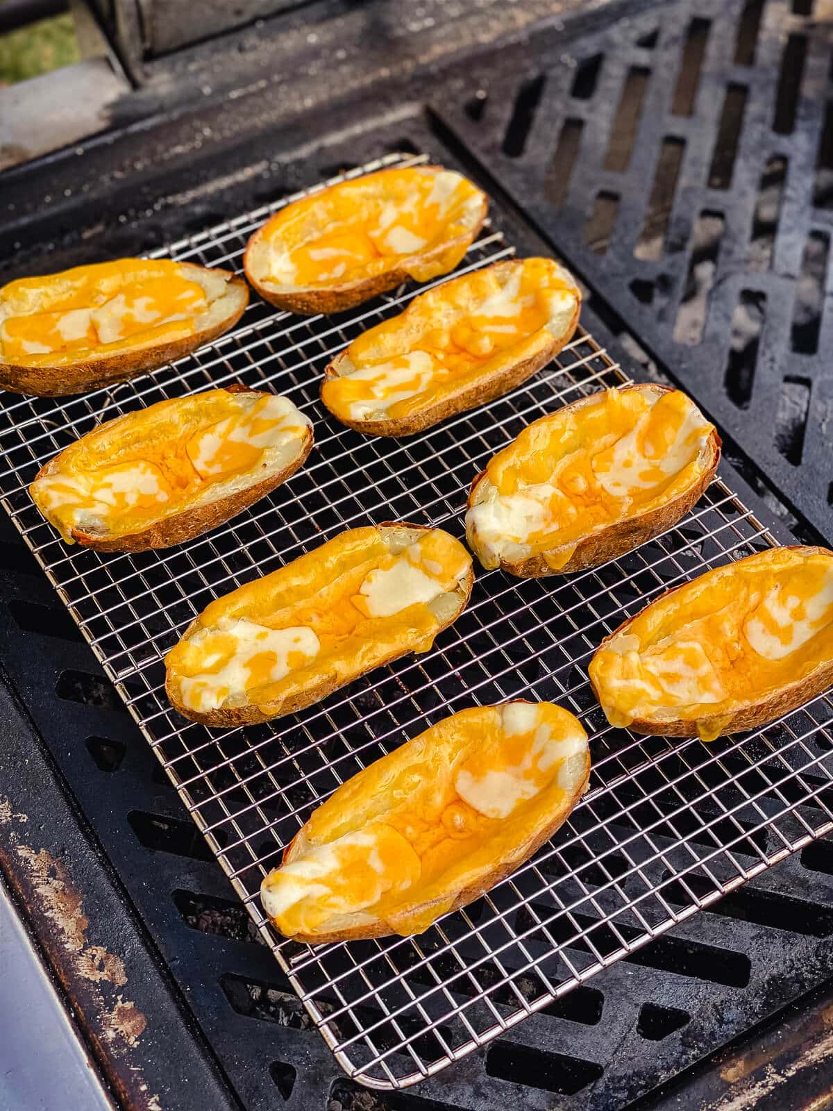 potatoes on a grill with melted cheese