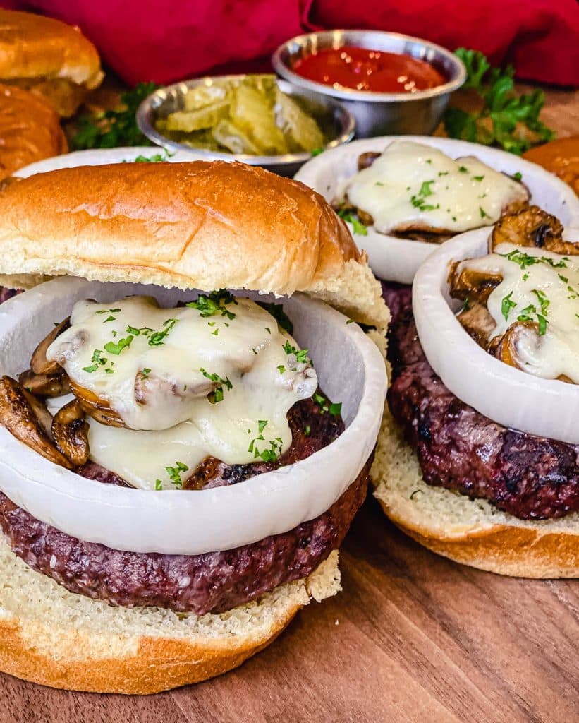venison burgers on a bun with melted cheese and mushrooms