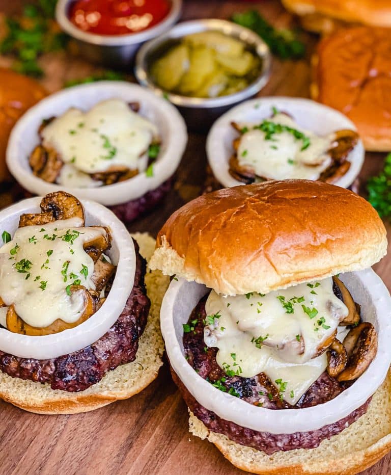 venison burgers on a platter with mushrooms and Swiss