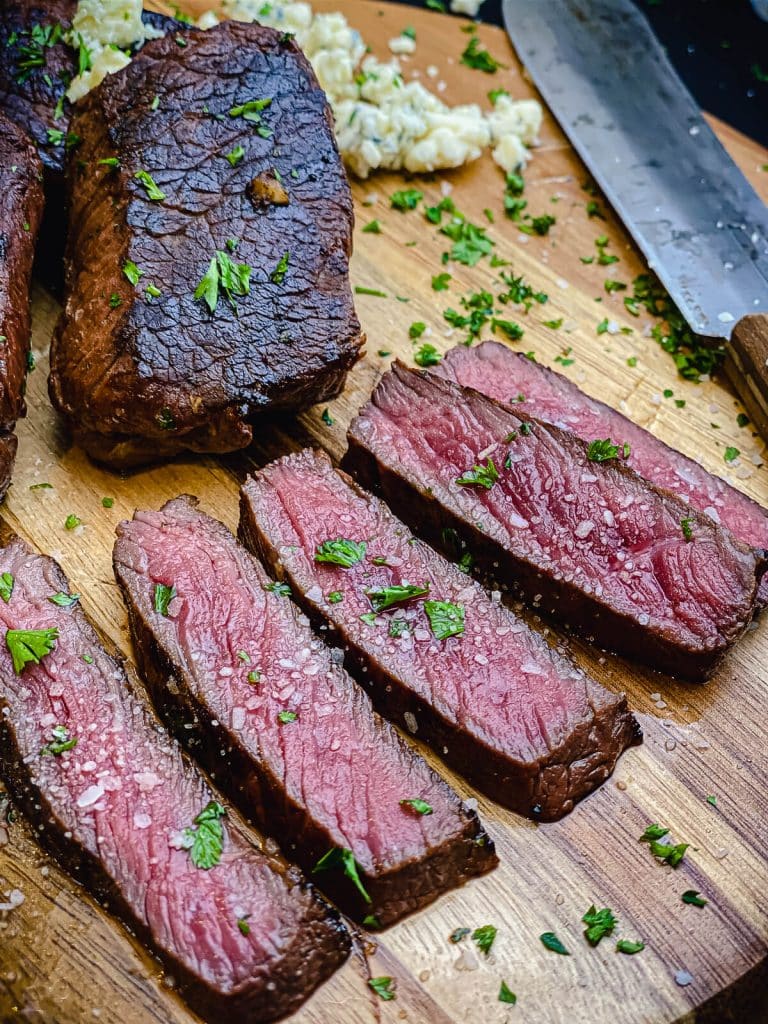 sliced venison steaks on a cutting board