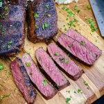 venison steaks sliced on a cutting board