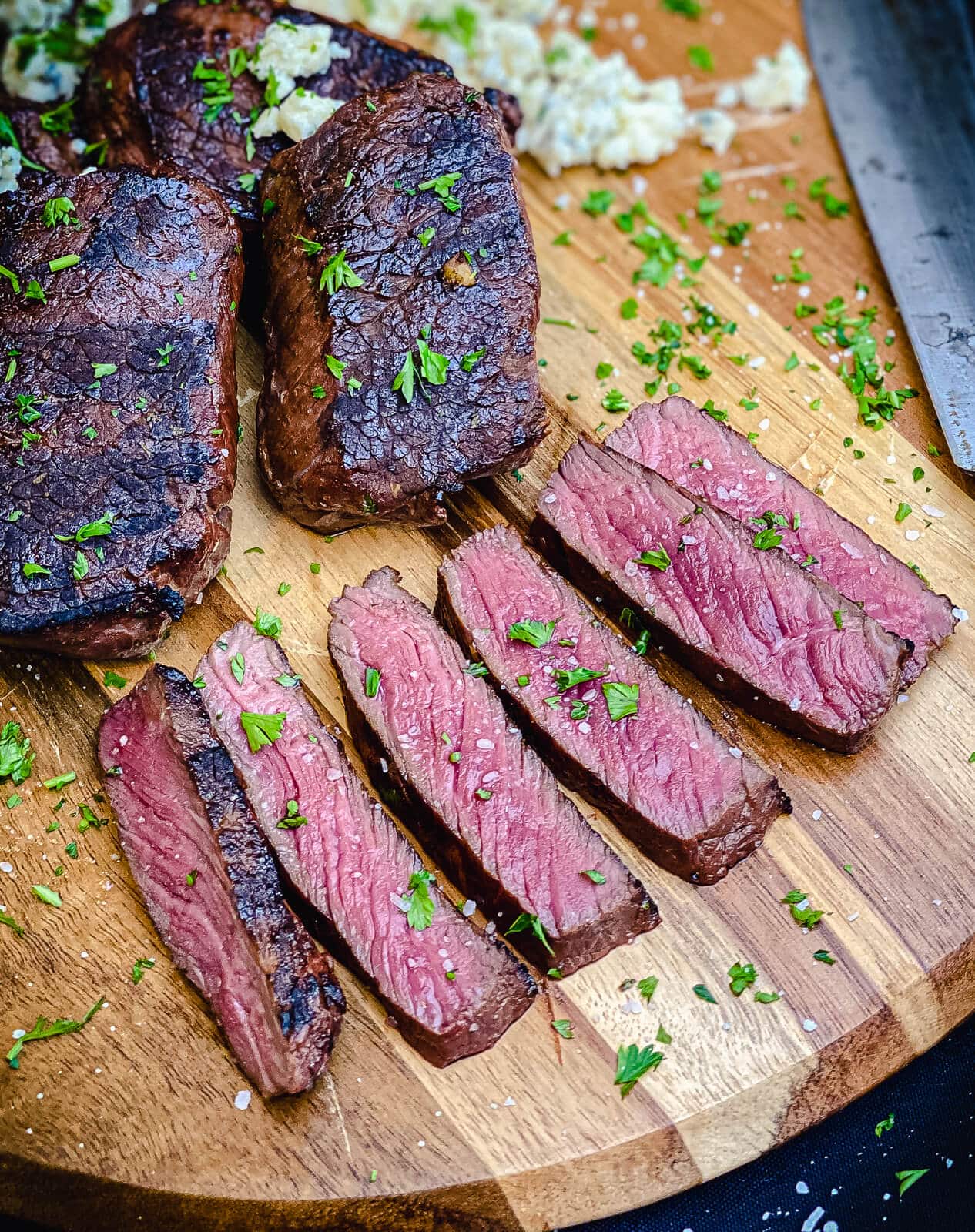 venison steaks sliced on a cutting board