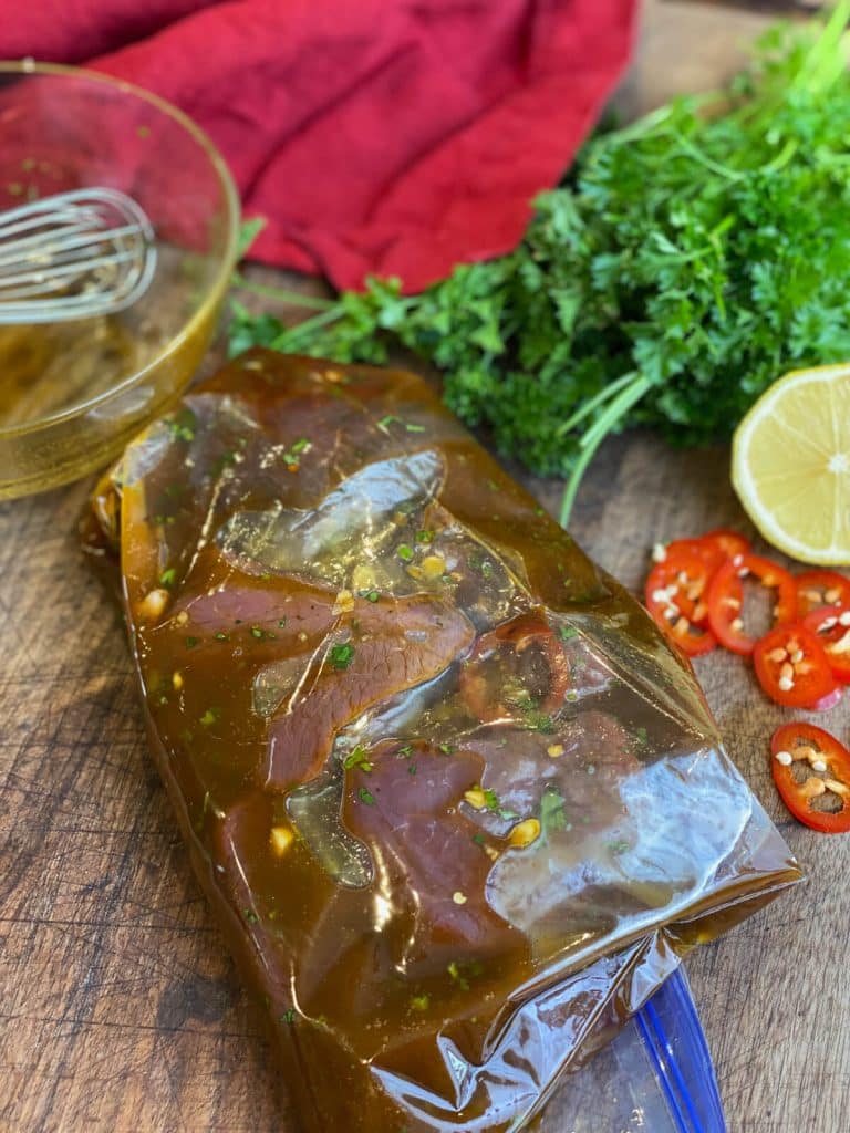 venison steaks marinating in a bag