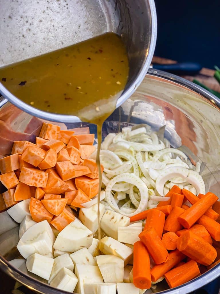 pouring miso maple glaze on top of root vegetables