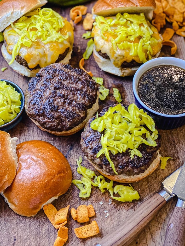 mississippi pot roast burgers on a wooden tray with knives