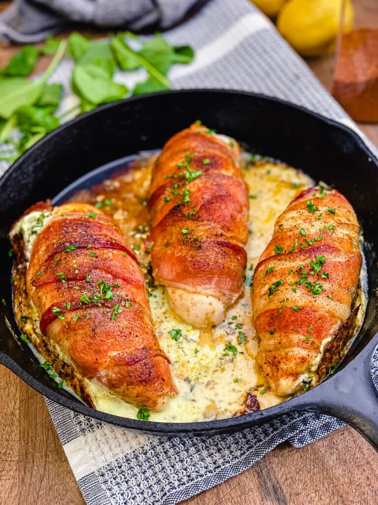 bacon wrapped stuffed chicken breast in a cast iron pan
