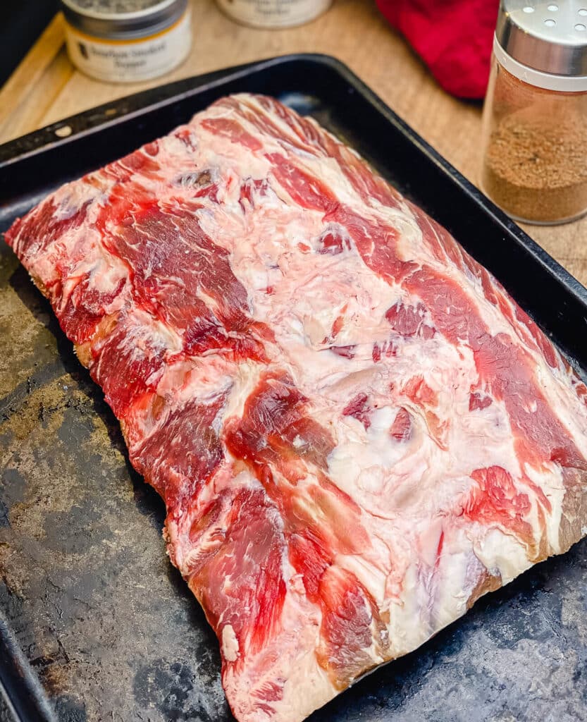 uncooked beef back ribs on a baking sheet